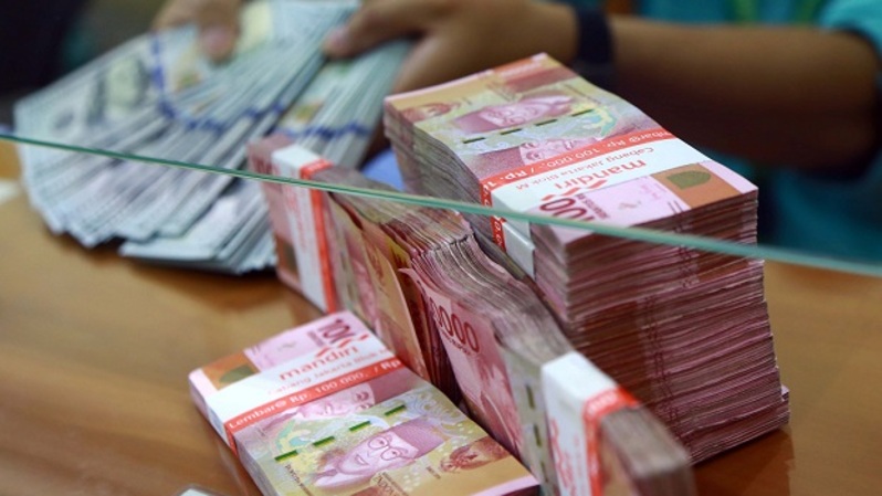 Karyawan menghitung uang dolar AS dan rupiah di tempat penukaran mata uang asing di Jakarta. Foto ilustrasi:  BeritaSatu Photo/Mohammad Defrizal