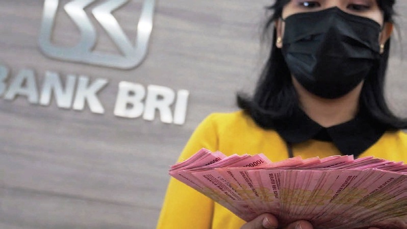 Teller menunjukkan uang rupiah di Bank BRI. Foto: Investor Daily/DAVID GITA ROZA