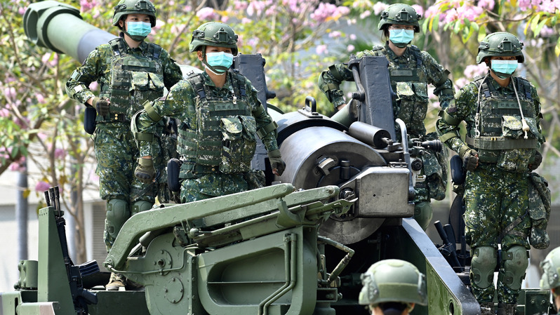 Tentara wanita Taiwan, mengenakan masker di tengah pandemi virus corona Covid-19, berdiri dalam formasi di atas artileri howitzer self-propelled M110A2 buatan Amerika Serikat (AS) selama kunjungan Presiden Taiwan Tsai Ing-wen ke pangkalan militer di Tainan, Taiwan selatan. ( Foto: SAM YEH / AFP )
