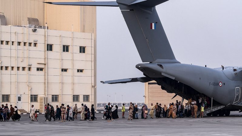 Masyarakat berjalan di landasan setelah turun dari pesawat angkut militer Airbus A400M di pangkalan udara militer Prancis 104 Al Dhafra, dekat Abu Dhabi, pada 23 Agustus 2021. Pesawat itu mengevakuasi warga Afghanistandari Kabul sebagai bagian dari operasi Apagan. ( Foto: BERTRAND GUAY / AFP ) 