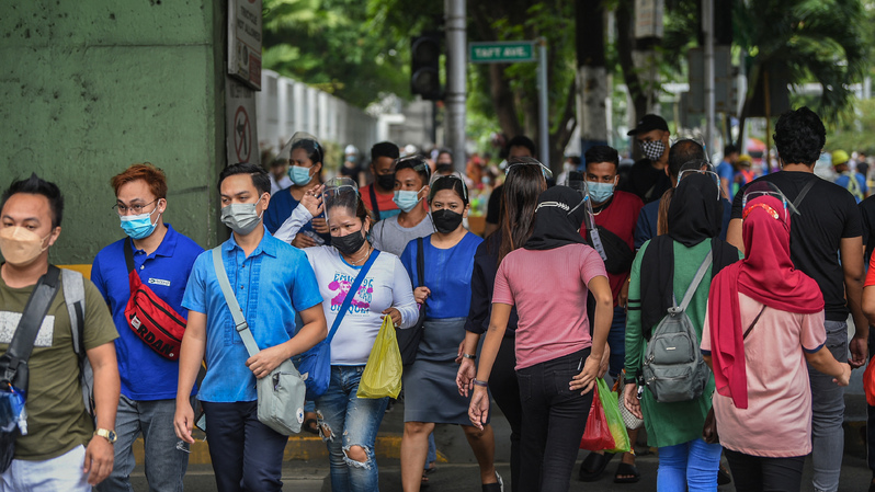 Masyarakat mengenakan masker dan pelindung wajah saat sedang menyeberang jalan di Manila pada 7 September 2021. ( Foto: TED ALJIBE / AFP )