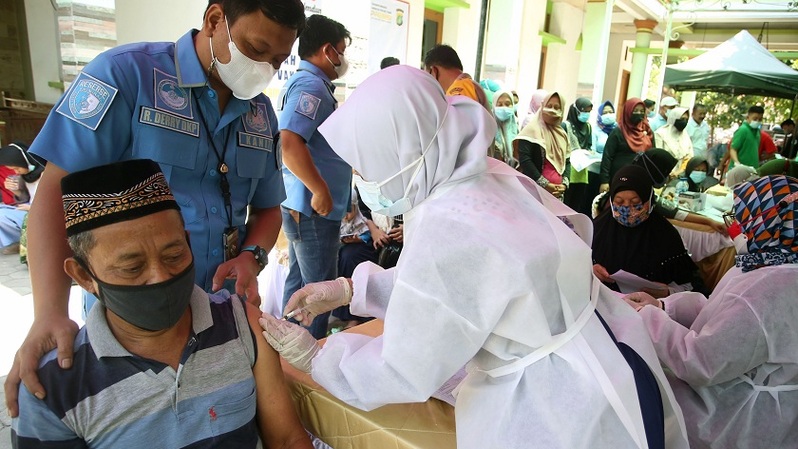 Petugas menyuntikkan vaksin Covid-19 saat pelaksanaan Vaksinasi Covid-19 masyarakat pinggiran Bandara Soekarno Hatta di Belendung, Tangerang, Banten. Foto ilustrasi:  BeritaSatu Photo/Mohammad Defrizal