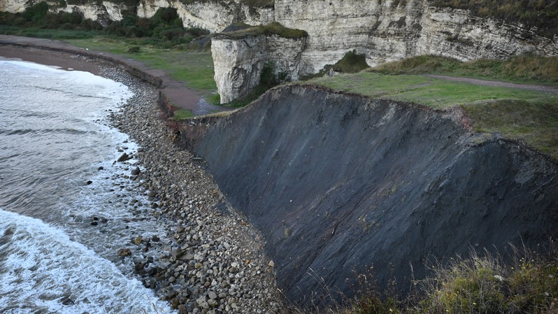 Sisa-sisa limbah batu bara dari tambang Dawdon Colliery yang dibuang langsung dari puncak tebing ke pantai, hingga penutupannya pada 1991, kini terlihat di tepi tebing di Pantai Blast di Seaham, timur laut Inggris pada 7 Oktober 2021. ( Foto: PAUL ELLIS / AFP )