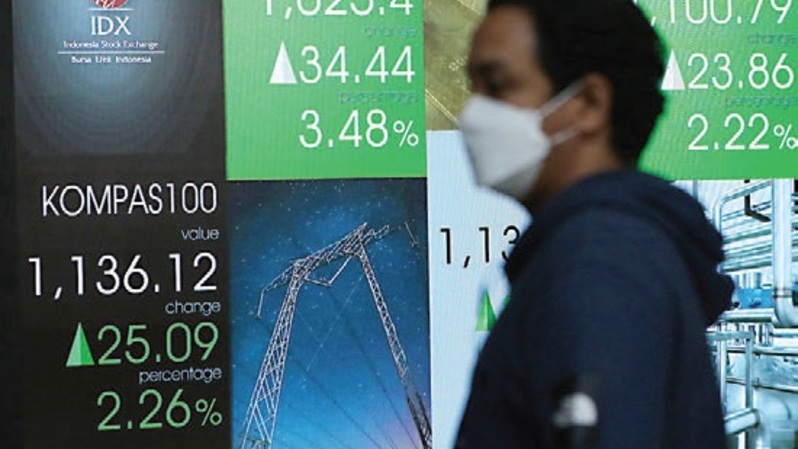 Pekerja melintasi layar pergerakan saham di gedung BEI, Jakarta. Foto ilustrasi: Investor Daily/David Gita Roza