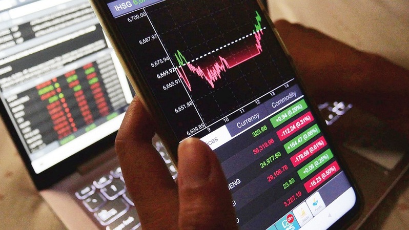 Seorang investor melihat pergerakan saham melalui smartphone di Jakarta. Foto ilustrasi: Investor Daily/David Gita Roza