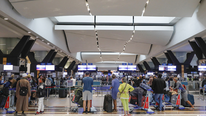 Para pelancong mengantre di konter check-in Bandara Internasional OR Tambo di Johannesburg, pada 27 November 2021, setelah beberapa negara melarang penerbangan dari Afrika Selatan menyusul ditemukannya varian baru Covid-19 Omicron. ( Foto: Phill Magakoe / AFP )