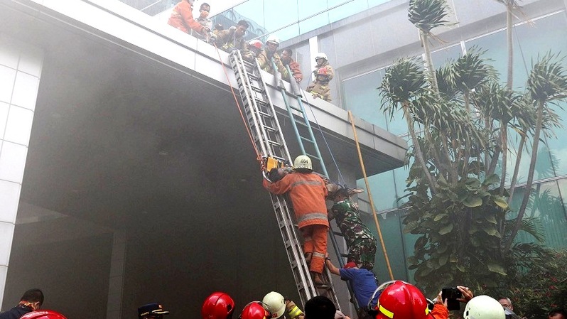 Sejumlah petugas pemadam kebakaran dengan peralatan lengkap melakukan evakuasi korban terjebak saat terjadi kebakaran di lantai 2 dan 3 gedung Cyber, Kuningan, Jakarta Selatan, Kamis (2/12/2021).  Foto; BeritaSatuPhoto/Joanito De Saojoao