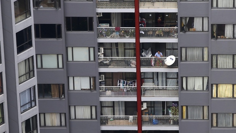 Penghuni berdiri di balkon sebuah apartemen di Jakarta. Foto ilustrasi: BeritaSatu Photo/Mohammad Defrizal