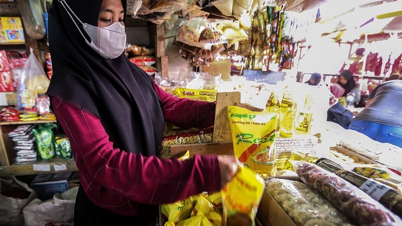 Pedagang pasar menunjukkan minyak goreng kemasan 1 liter di sebuah pasar tradisional di Jakarta, Rabu (19/1/2022). Foto ilustrasi:  BeritaSatuPhoto/Joanito De Saojoao