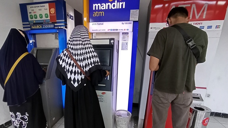 Nasabah melakukan transaksi menggunakan mesin anjungan tunai mandiri (ATM) di Pamulang, Tangerang Selatan, Banten, Minggu (23/1/2022). Foto ilustrasi: BeritaSatu Photo/Mohammad Defrizal