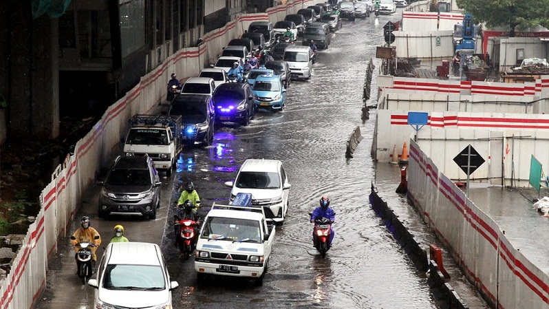 Sejumlah kendaraan melintas genangan air akibat hujan deras di Jalan Rasuna Said, Jakarta, Selasa (8/2/2022).  Foto: BeritaSatuPhoto/Joanito De Saojoao