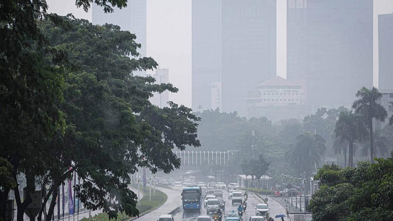 Arus kendaraan melintas saat hujan disertai angin kencang terjadi di Jalan Sudirman