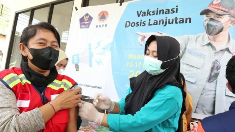 Vaksinator menyuntikkan vaksin Covid -19 kepada masyarakat peserta Vaksinasi Mobile di Kantor Desa Kuta, Kecamatan Pujut, Lombok Tengah, Nusa Tenggara Barat, Minggu (13/3/2022). Foto BNPB
