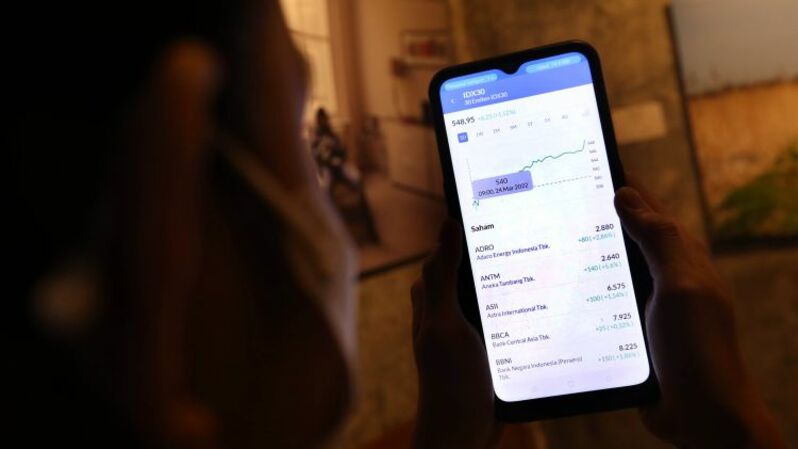 Investor melihat pergerakan saham melalui layar smartphone di Jakarta. Foto ilustrasi: BeritaSatu Photo/Mohammad Defrizal 
