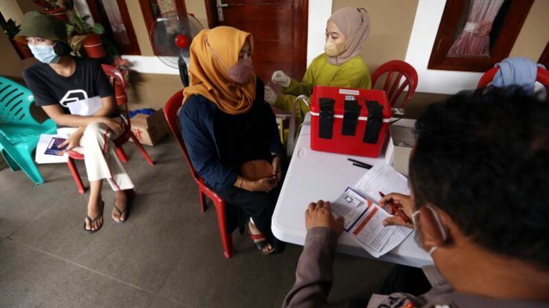 Tenaga kesehatan memberikan suntkan vaksin Covid-19 dosis booster kepada warga perumahan di Vila Pamulang, Pondok Petir, Bojongsari, Depok, Jawa Barat, Sabtu (26/3/2022).  Foto ilustrasi: BeritaSatu Photo/Mohammad Defrizal 