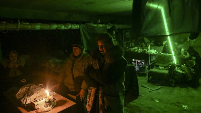 Warga berlindung di ruang bawah tanah sebuah sekolah tempat mereka tinggal selama sebulan, di sepanjang distrik garis depan Kharkiv pada 27 Maret 2022. Pasukan Rusia berkemah beberapa kilometer dari sekolah, menjarah tempat itu setiap hari. (FOTO: ARIS MESSINIS / AFP)