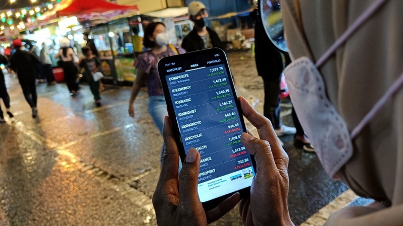 Seorang investor melihat pergerakan saham melalui smartphone. (BeritaSatu Photo/Mohammad Defrizal)