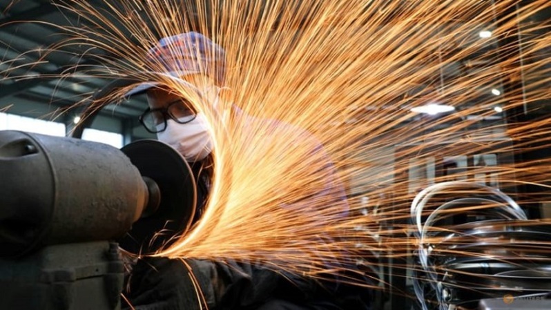 Pekerja yang mengenakan masker bekerja di jalur produksi pembuatan baja sepeda di sebuah pabrik, saat negara itu dilanda wabah virus corona baru di Hangzhou, Provinsi Zhejiang, Tiongkok, beberapa waktu lalu. (FOTO: China Daily via REUTERS)