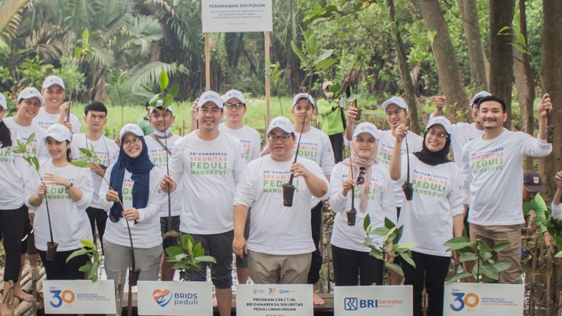 Plt Direktur Utama BRI Danareksa Sekuritas (BRIDS) Hendra Hermawan (tengah) didampingi Corporate Secretary Moh Burhan S Widodo (ketiga dari kiri) berfoto bersama pegawai di sela kegiatan CSR penanaman 300 pohon mangrove di PIK Jakarta. 