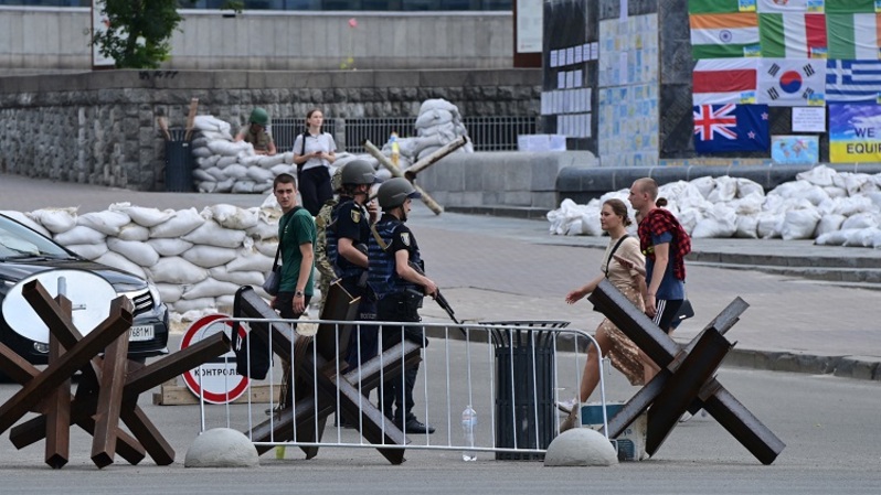 Tentara Ukraina berdiri di pos pemeriksaan melewati pejalan kaki di Kyiv tengah pada 30 Juni 2022, di tengah serangan Rusia ke Ukraina. (FOTO: Miguel MEDINA / AFP)