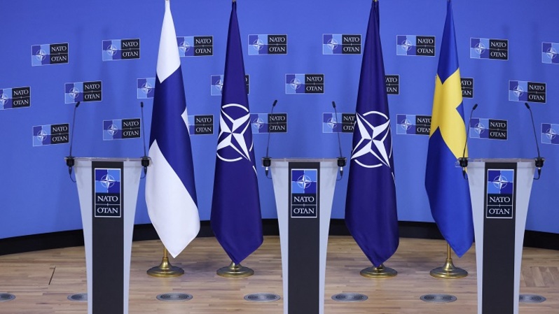 Bendera Finlandia, NATO, dan Swedia terlihat sebelum konferensi pers di markas NATO Brussel, Belgia pada 5 Juli 2022. (FOTO: Kenzo TRIBOUILLARD / AFP)