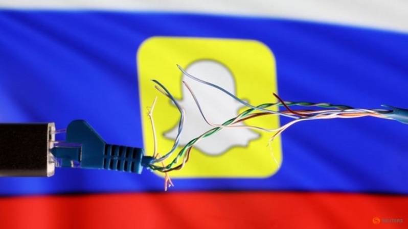 Kabel Ethernet yang putus terlihat di depan bendera Rusia dan logo SnapChat pada 11 Maret 2022. (FOTO: REUTERS/Dado Ruvic)
