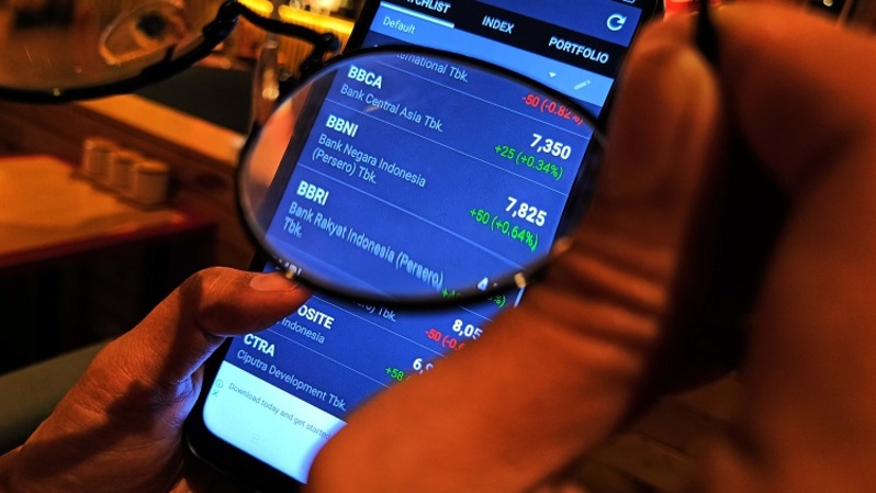 Investor memantau pergerakan harga saham melalui smartphone. (BeritaSatu Photo/Mohammad Defrizal)