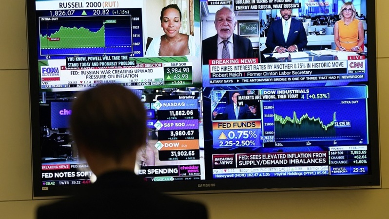 Seseorang di lantai Bursa Efek New York (NYSE) menonton layar TV pada 27 Juli 2022. (FOTO: TIMOTIUS A. CLARI / AFP)