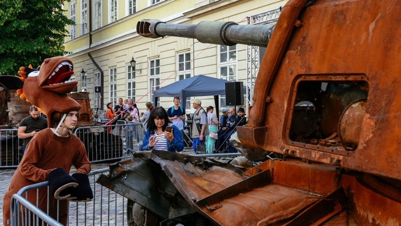 Warga melihat peralatan militer Rusia yang hancur dalam pertempuran dengan tentara Ukraina, ditampilkan sebagai bagian dari pameran di alun-alun pusat Lviv pada 11 Agustus 2022. (FOTO: YURIY DYACHYSHYN / AFP)