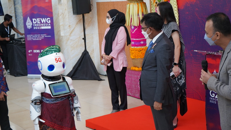 Menteri Komunikasi dan Informatika Johnny G. Plate saat berinteraksi dengan Artificial Intelligence (AI) Robot serta memantau beberapa showcase 5G Telkomsel pada kegiatan DEWG ke-4 di Bali. (Foto: Dok.PR)