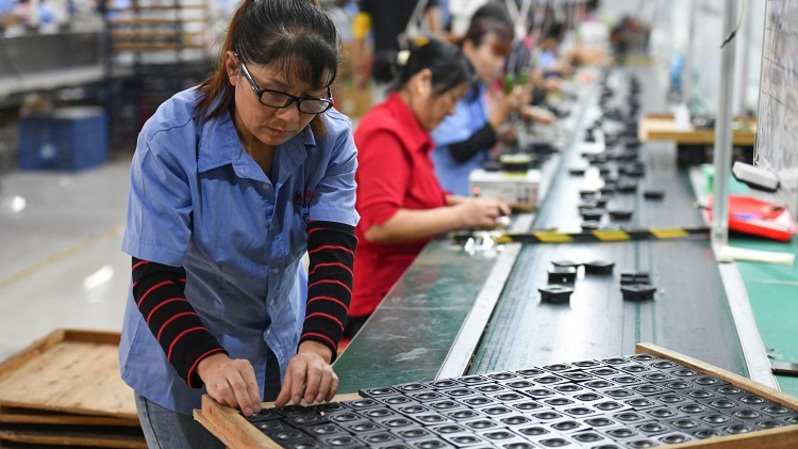 Karyawan bekerja di jalur perakitan yang memproduksi speaker di sebuah pabrik Fuyang, Provinsi Anhui timur Tiongkok pada 31 Agustus 2022. (FOTO: STR / AFP)
