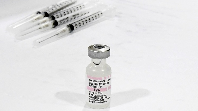 Botol Sodium Chloride untuk pengenceran vaksin Covid-19 terlihat dalam persiapan vaksinasi pada hari pembukaan pusat vaksinasi Covid-19 skala besar di gedung parkir Cal Poly Pomona University di Pomona, California pada 5 Februari 2021. (FOTO: Frederic J. BROWN / AFP)