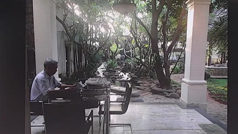 Lo Kheng Hong saat membaca koran di taman rumahnya. (YouTube @SimInvest)