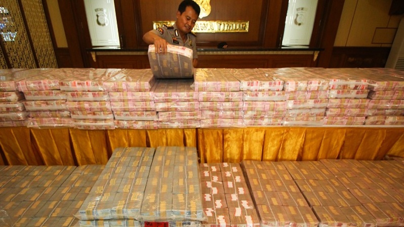 Polisi menata barang bukti uang tunai rupiah kasus investasi ilegal. (ANTARA FOTO/Didik Suhartono/foc)
