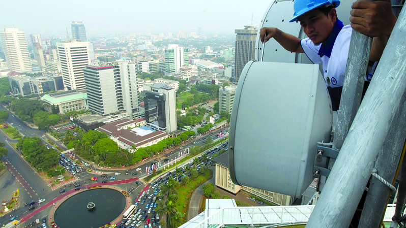 Teknisi melakukan perawatan fasilitas antena gelombang pendek Indosat di Jakarta. (Dok. BeritaSatu Photo)