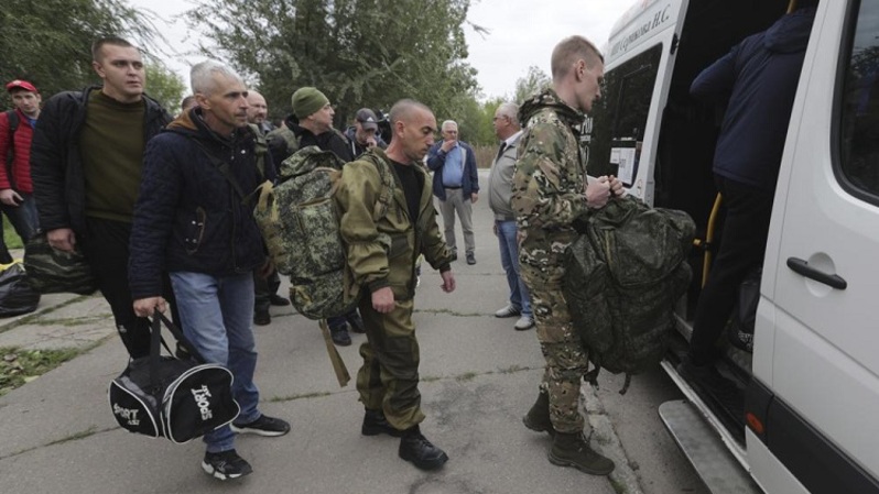 Sejumlah pria Rusia menaiki bus di pusat rekrutmen militer di Volzhskiy, Volgograd, Rusia pada 28 September 2022. Presiden Rusia Vladimir Putin telah memerintahkan mobilisasi sebagian pasukan cadangan untuk memperkuat militernya di Ukraina. (Foto: AP)