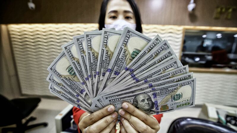 Petugas jasa penukaran mata uang asing menunjukan pecahan uang dolar Amerika Serikat dan pecahan uang Rupiah di tempat jasa penukaran uang di Jakarta.