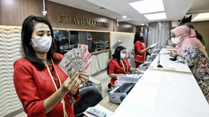 Petugas jasa penukaran mata uang asing menunjukan pecahan uang dolar Amerika Serikat dan pecahan uang Rupiah di tempat jasa penukaran uang di Kwitang, Jakarta Pusat. (BeritaSatuPhoto/Joanito De Saojoao)