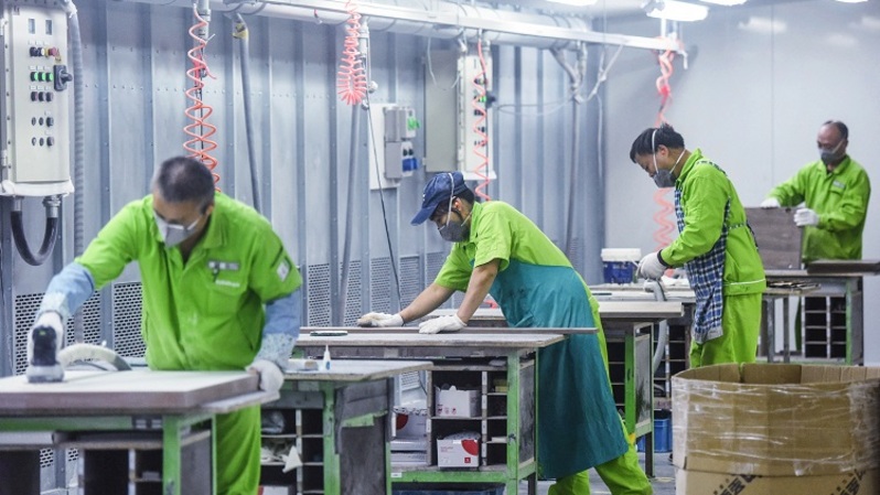 Pekerja memproduksi furnitur di sebuah pabrik di Hangzhou, Provinsi Zhejiang timur Tiongkok pada 24 Oktober 2022. (FOTO: STR / AFP)