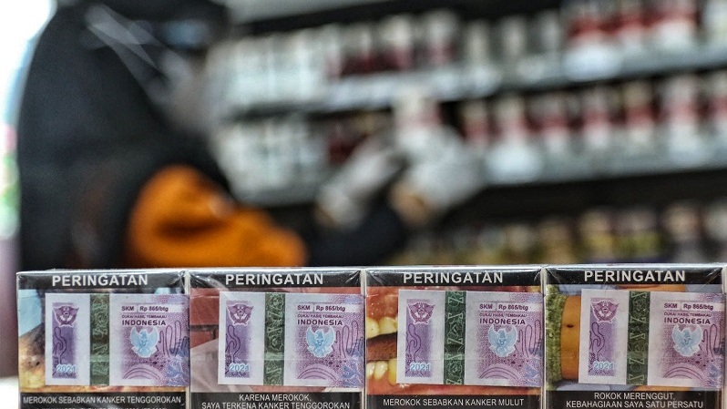 Pramuniaga merapikan rak penjualan rokok tembakau di salah satu gerai mini market di Jakarta. (B Universe Photo/Joanito De Saojoao)