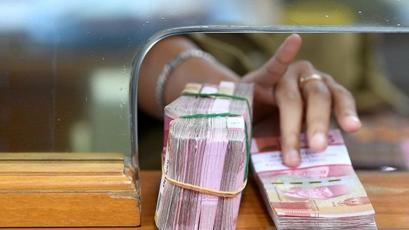 Karyawan memegang mata uang rupiah di gerai penukaran mata uang asing di Jakarta Pusat. (Foto: ANTARA FOTO/Sigid Kurniawan/aww)