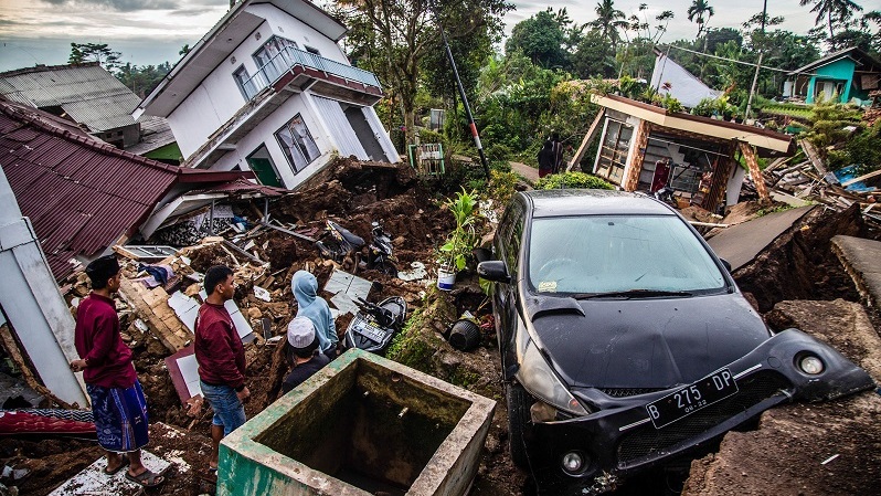 Warga menyelamatkan barang-barang dari rumah yang rusak pada 22 November 2022 akibat gempa bermagnitudo 5,6 di Cianjur, Jawa Barat. (Foto: ADITYA AJI/AFP)