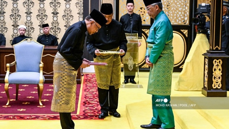 Raja Malaysia Al-Sultan Abdullah Sultan Ahmad Shah (kanan) dan Perdana Menteri Malaysia yang baru diangkat Anwar Ibrahim (kiri) mengambil bagian dalam upacara pengambilan sumpah di Istana Nasional di Kuala Lumpur pada 24 November 2022. (FOTO: MOHD RASFAN / POOL / AFP)