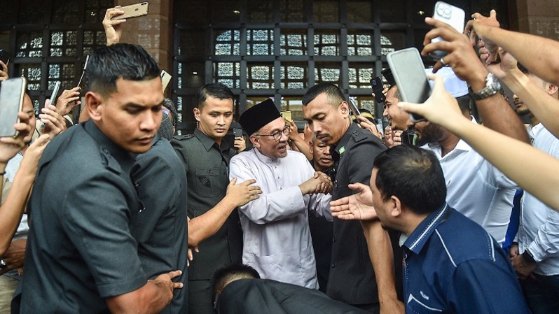 Perdana Menteri Malaysia Anwar Ibrahim menyapa warga saat meninggalkan Masjid Putra usai salat di Putrajaya pada 25 November 2020. (Foto: Arif Kartono/AFP)
