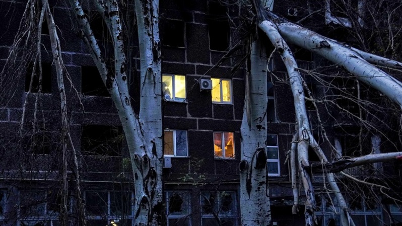 Cahaya di jendela sebuah gedung apartemen di kota pelabuhan Mariupol dekat Laut Azov yang dikuasai Rusia di tenggara Ukraina pada 28 November 2022. (FOTO: STRINGER / AFP)