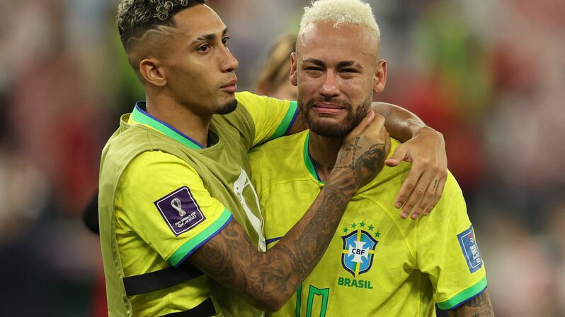Penyerang Brasil Neymar (kanan) tak mampu menyembunyikan tangisnya, berjalan bersama tekan setimnya Raphinha, seusai kalah dari Kroasia lewat adu penalti saat perempat final Piala Dunia 2022, di Education City Stadium, Qatar, Jumat, 9 Desember 2022.