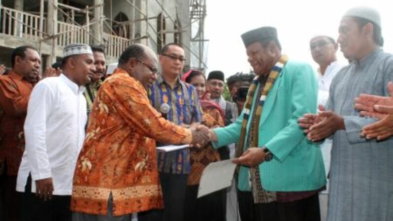 Gubernur  Papua Lukas Enembe (baju kuning) bersalaman dengan pemimpin umat Islam di Papua