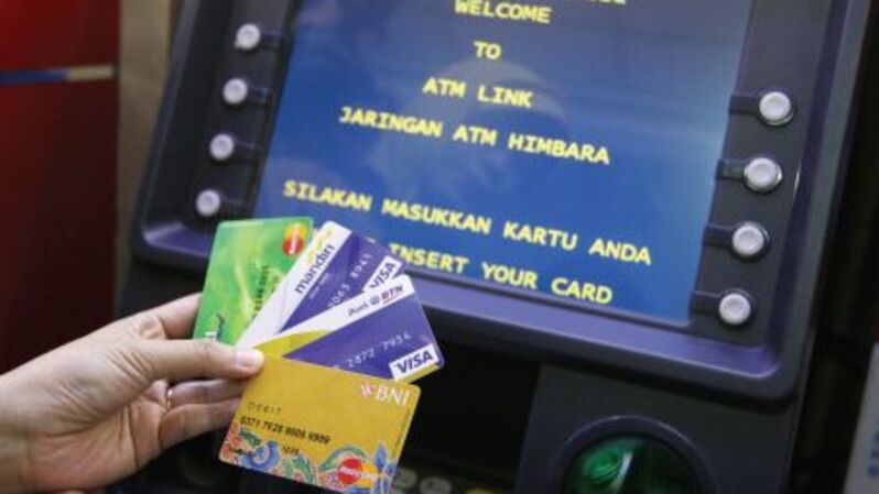 Nasabah menunjukkan kartu ATM di depan mesin ATM Himbara. (Foto: Investor Daily/David Gita Roza)
