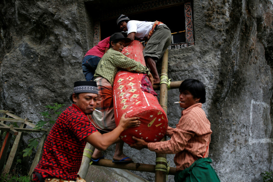 Men remove a coffin from a burial chamber. (Reuters Photo/Darren Whiteside)