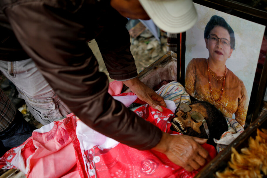 A man fixes a blanket around the mummified body of a relative. (Reuters Photo/Darren Whiteside)